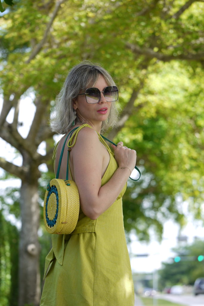 Alba Marina Otero fashion blogger from Mylovelypeople blog shares with you how to combine a linen dress with cowboy boots, with a rounded raffia bag, maxi sunglasses and statements earrings. The history of cowboy boots and how they become a staple fashion footwear.