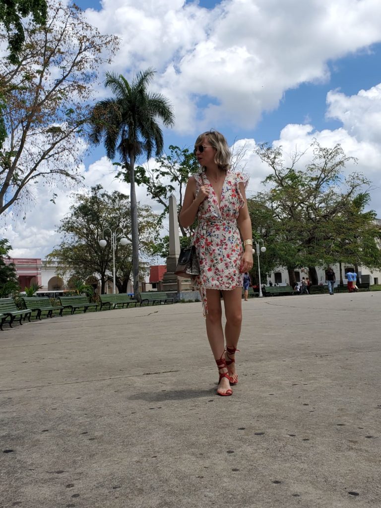 Alba Marina Otero fashion blogger from Mylovelypeople blog shares with you how to combine a flower wrap dress to make tourism in a hot day during her last trip to Cuba, combine it with red block sandals, a coach bag and golden accesories. She also shares with you a little bit of history about Vidal Park which is located in Santa Clara city.